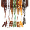 Mano sosteniendo un Tasbih de color vibrante del pack de 7, con fondo desenfocado