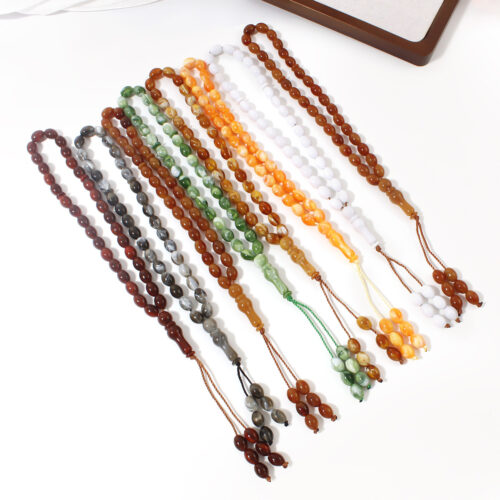 Pack de 7 Tasbihs de colores variados (rojo, azul, verde, amarillo, etc.) sobre tela de oración
