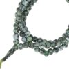 Primer plano de una cuenta de Tasbih mostrando un Nombre de Allah caligrafiado